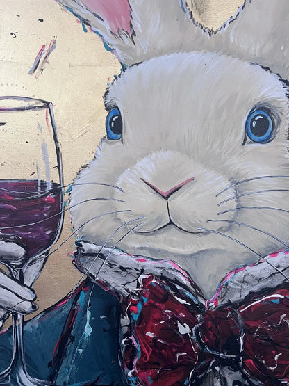 Close-up of the white rabbit’s blue eyes, painted fur, wine glass and layered bow tie in Never too late – Party time.