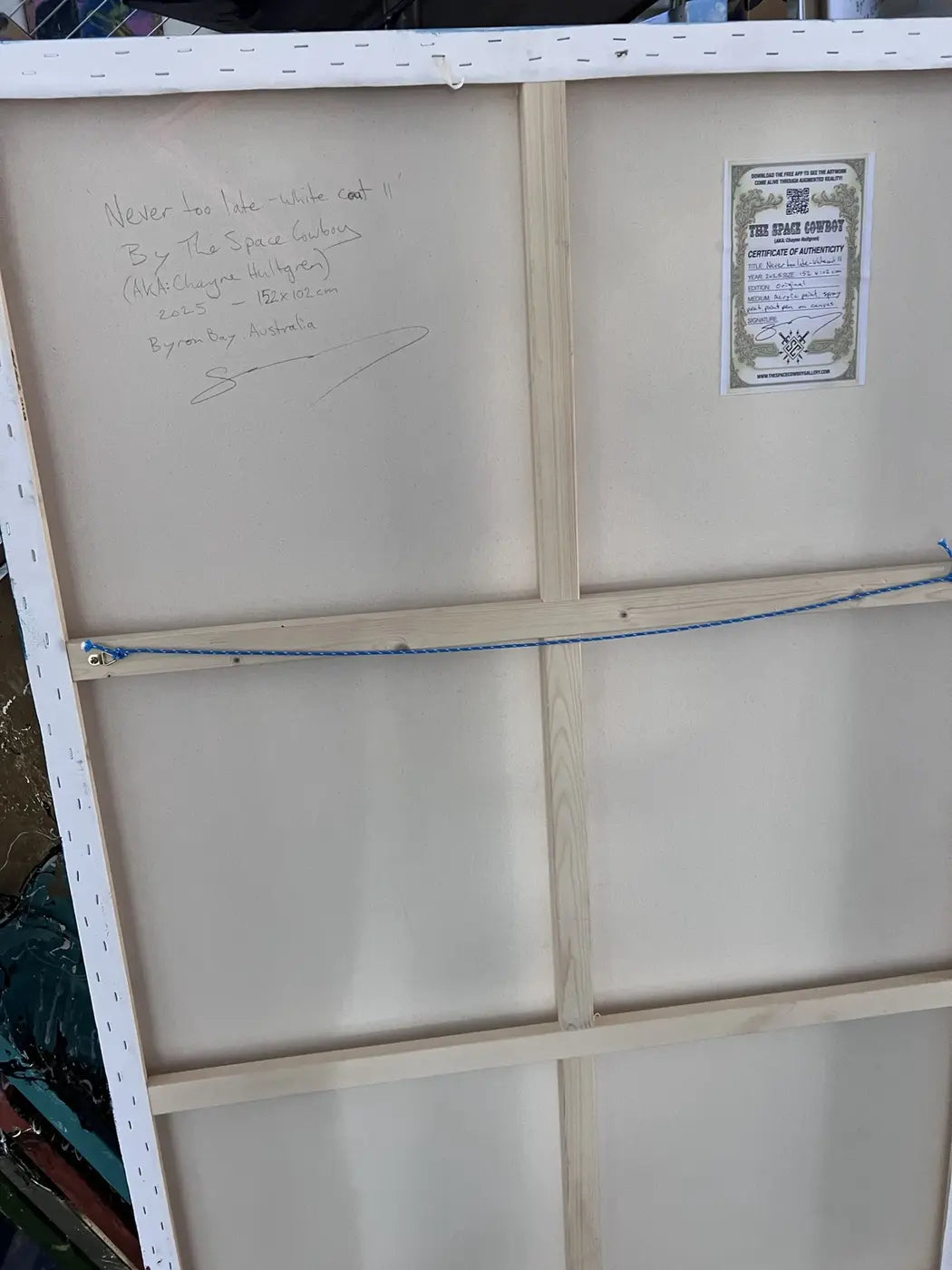 Back of Never too late -white coat II showing the signed canvas, Certificate of Authenticity and hanging wire.