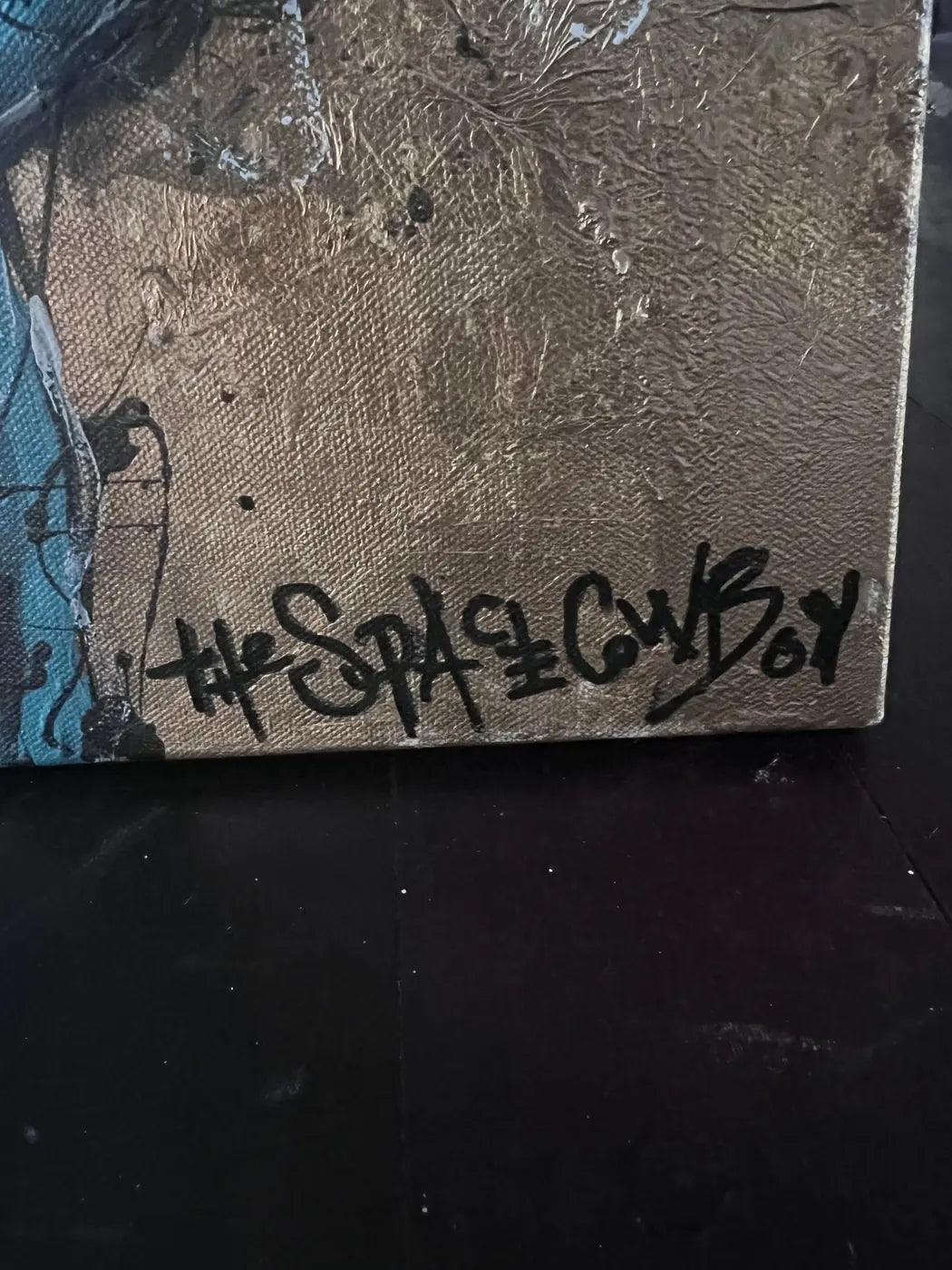 Close-up of The Space Cowboy’s signature over the textured gold ground of Tie Grrr Luxe II.